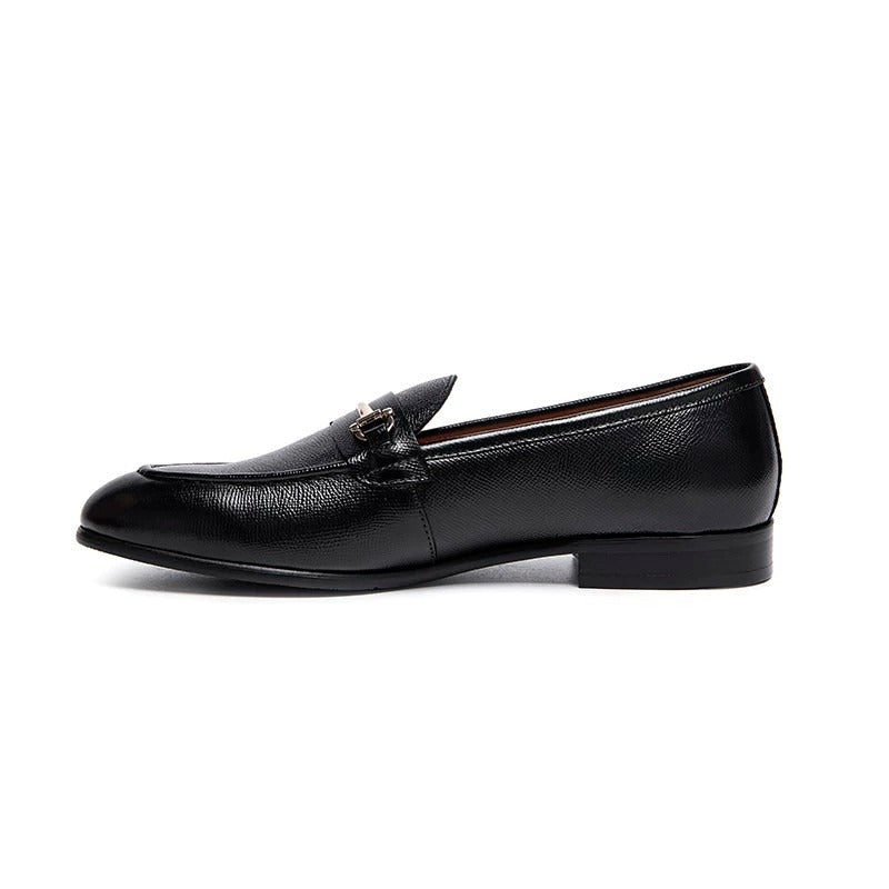 Lunepebbla black leather horsebit loafers worn with tailored trousers showing gold buckle