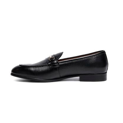Lunepebbla black leather horsebit loafers worn with tailored trousers showing gold buckle