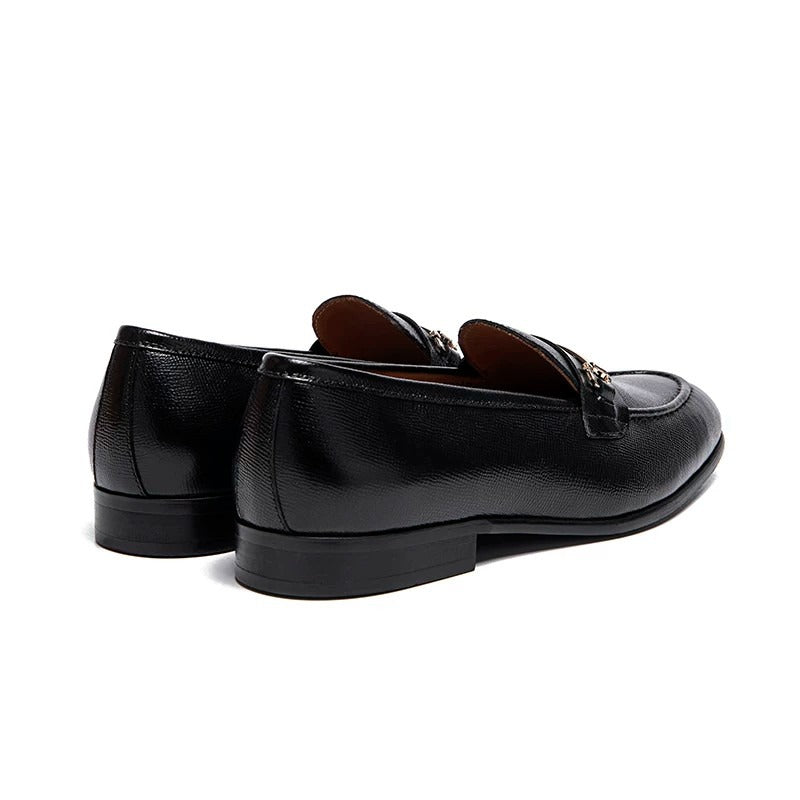 Lunepebbla black leather horsebit loafers worn with dark trousers showing polished leather